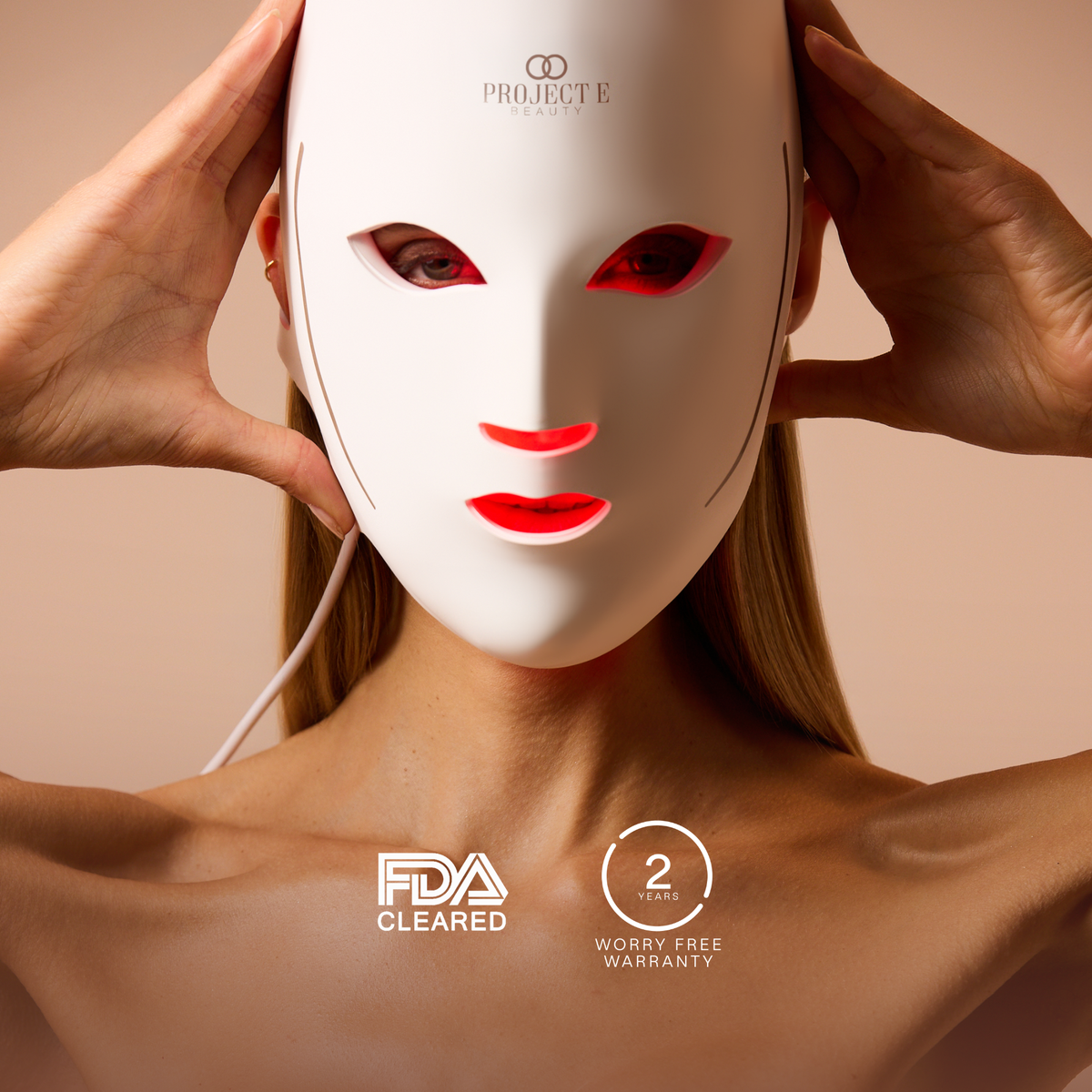 Woman wearing LumaLux Face V2 beside regulatory-clearance and warranty badges