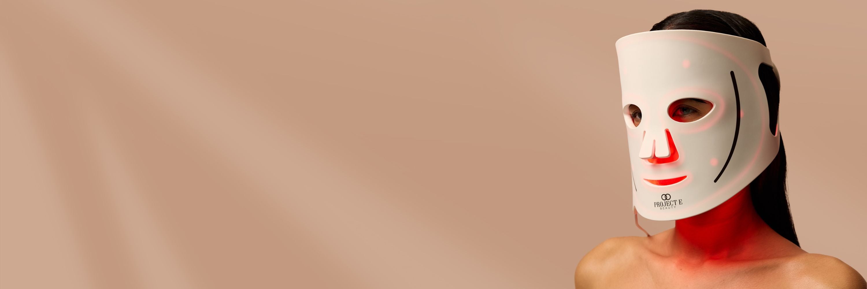 Woman using a full‑face LED light therapy mask