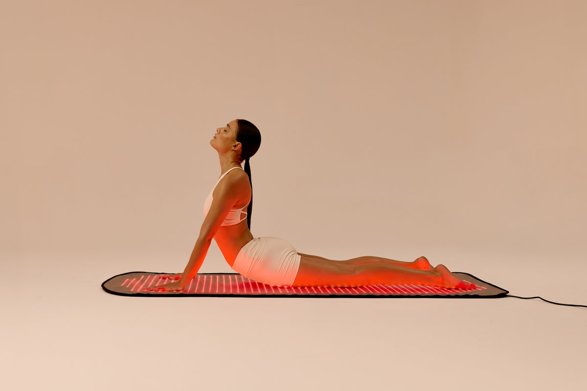 Woman stretching on the Restora red light therapy mat